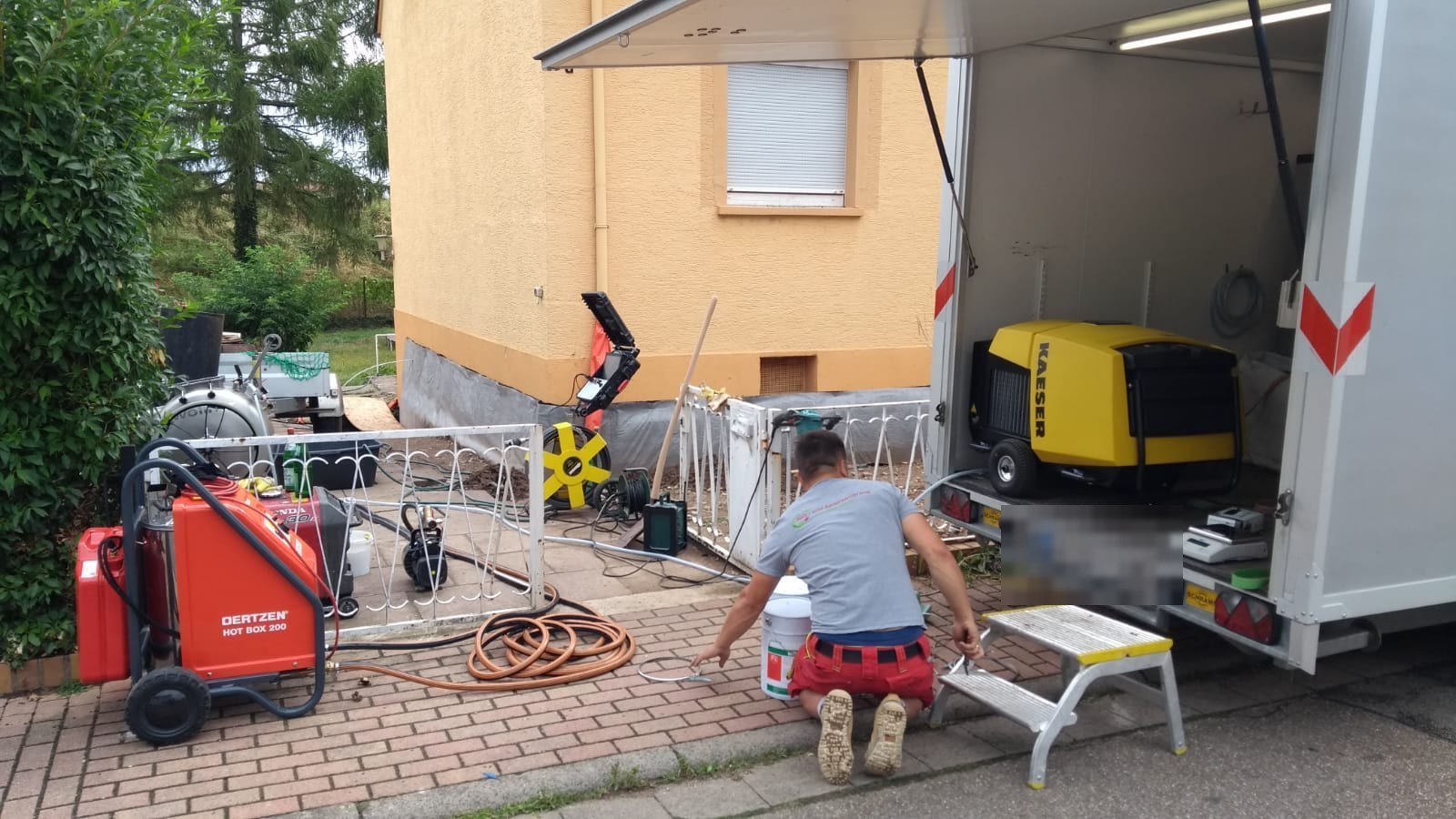 Mitarbeiter am Kofferfahrzeug mit Kompressor und Hochdrucktechnik