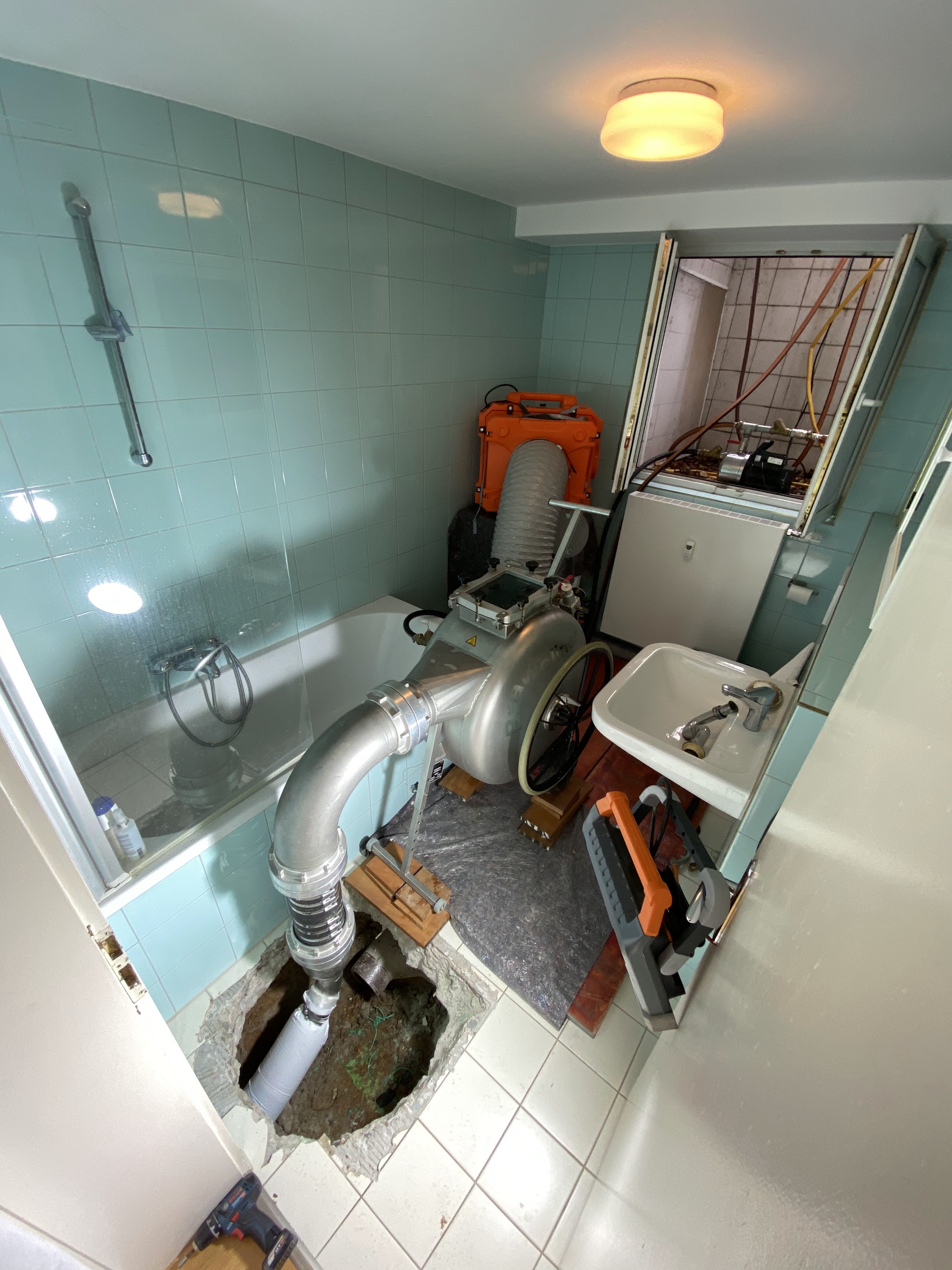 Badezimmer mit geöffnetem Boden und Sanierungstechnik